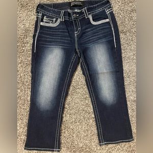 Dark wash blue jean capris with pocket embellishments